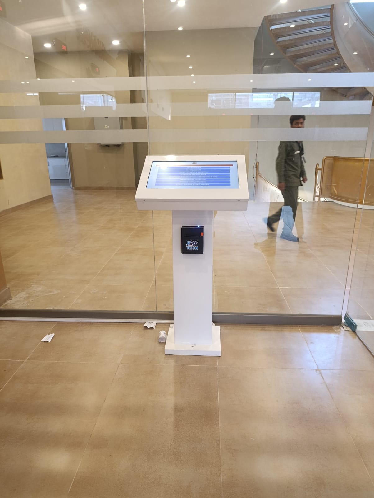 24-inch H-TECH Ticket Dispenser — angled full-unit kiosk with service menu and printer in a lobby